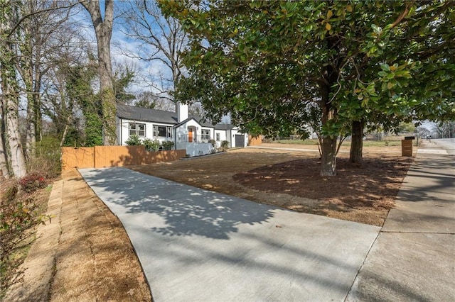 view of front of property with concrete driveway and fence