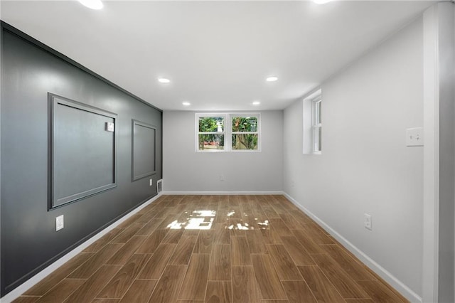 spare room with recessed lighting, baseboards, and wood finished floors