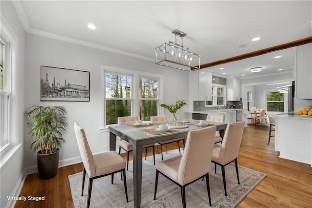 dining room with baseboards, ornamental molding, recessed lighting, and light wood-style floors