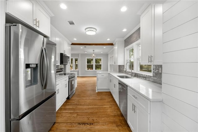 kitchen with dark wood-style floors, visible vents, appliances with stainless steel finishes, white cabinetry, and a sink