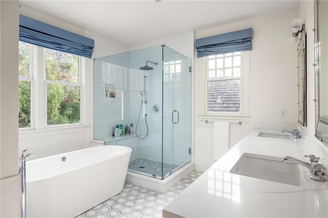 bathroom with shower with separate bathtub, a healthy amount of sunlight, and sink