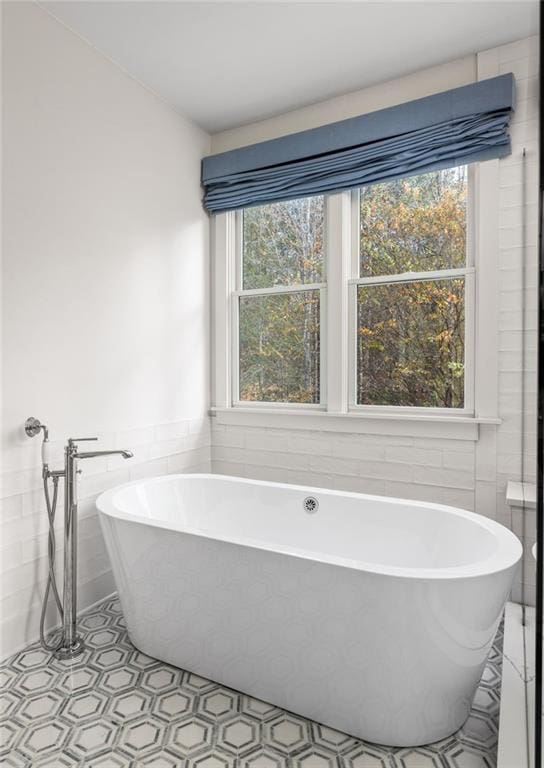 bathroom featuring a tub and tile walls