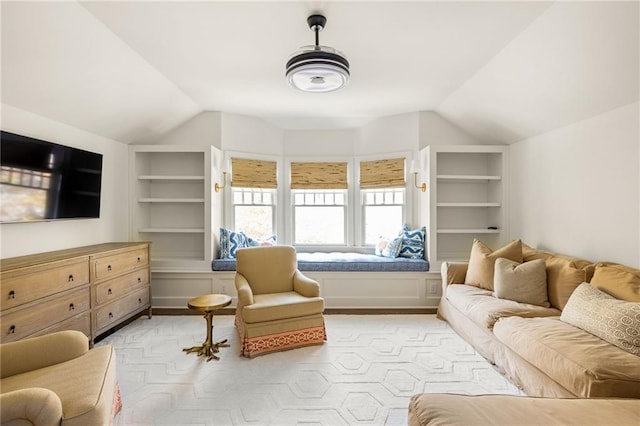 living room featuring built in shelves, lofted ceiling, and light parquet flooring