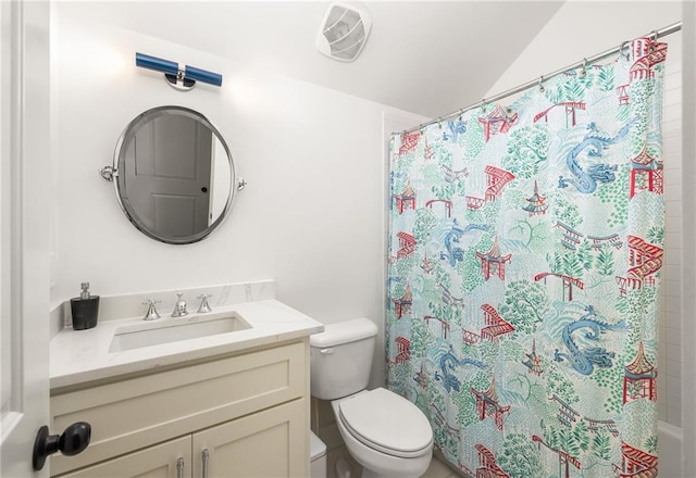 bathroom featuring vanity, vaulted ceiling, and toilet