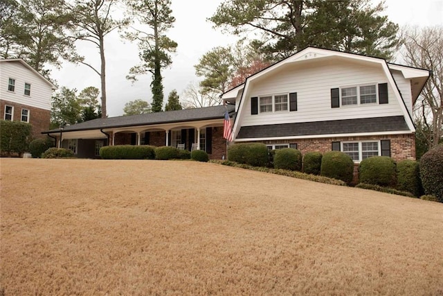 view of front facade with brick siding and a gambrel roof