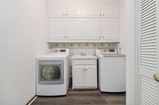 laundry room with cabinets, dark hardwood / wood-style flooring, washer and clothes dryer, and sink