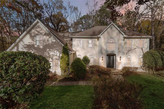 view of front of home featuring a lawn and french doors