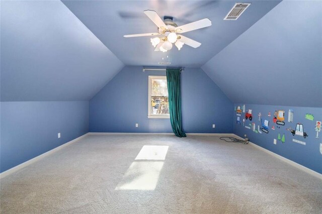 carpeted living room with ceiling fan and vaulted ceiling