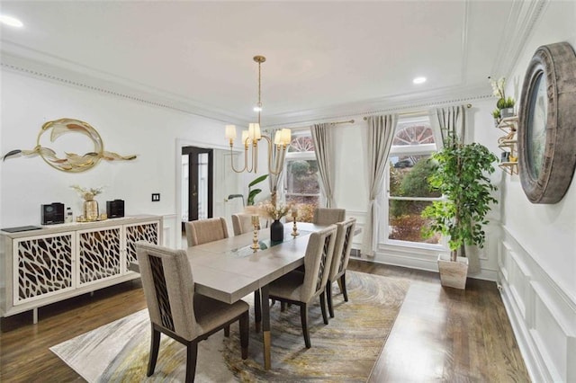 dining area featuring dark wood-type flooring, an inviting chandelier, and ornamental molding