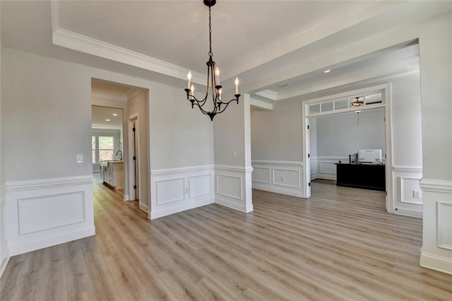 6867 Kate Ln, Flowery Branch, GA 30542 - unfurnished dining area with a chandelier, light wood finished floors, a decorative wall, crown molding, and a wainscoted wall