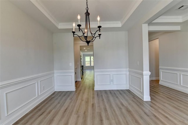 6867 Kate Ln, Flowery Branch, GA 30542 - unfurnished dining area with a chandelier, light wood finished floors, a raised ceiling, ornamental molding, and a wainscoted wall