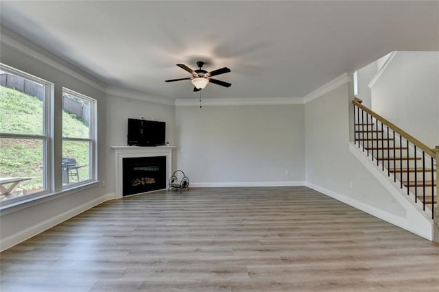 6867 Kate Ln, Flowery Branch, GA 30542 - unfurnished living room with healthy amount of natural light, ornamental molding, a fireplace, light wood-style flooring, and stairway