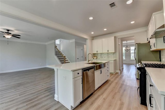 6867 Kate Ln, Flowery Branch, GA 30542 - kitchen with dishwasher, range with gas stovetop, crown molding, light wood-style floors, and an island with sink