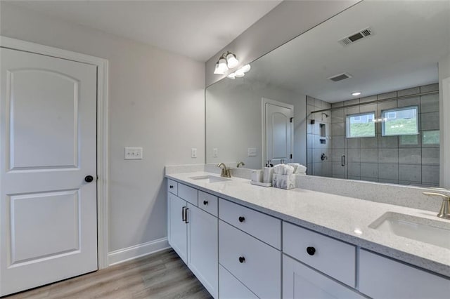 6867 Kate Ln, Flowery Branch, GA 30542 - bathroom featuring double vanity, a stall shower, and wood finished floors