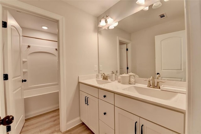 6867 Kate Ln, Flowery Branch, GA 30542 - bathroom featuring double vanity, wood finished floors, and tub / shower combination