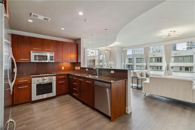 20 10th St NW Unit 704, Atlanta, GA 30309 - kitchen with stainless steel appliances, a peninsula, open floor plan, wood finished floors, and recessed lighting