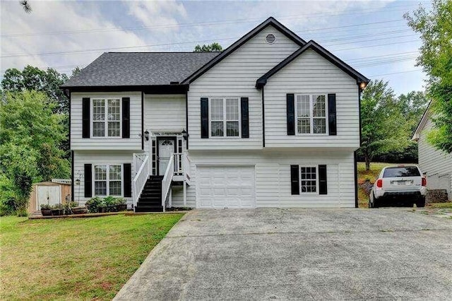 raised ranch featuring a garage and a front yard