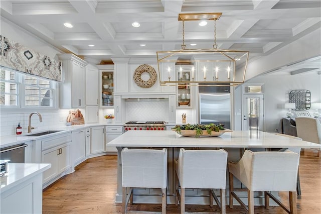 kitchen with stainless steel appliances, a sink, a center island, and white cabinets