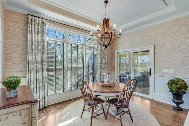 dining area with visible vents, ornamental molding, and wood finished floors