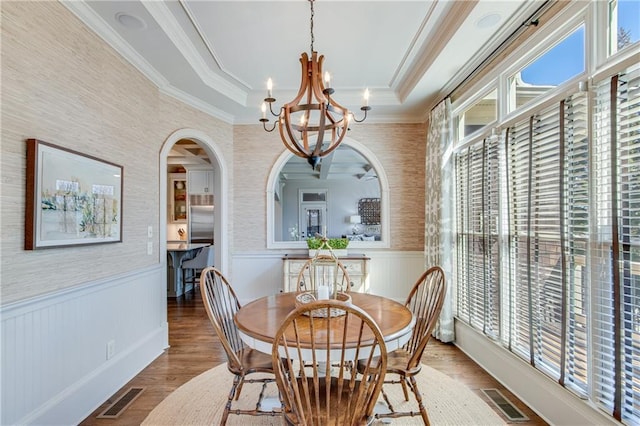 dining area featuring a chandelier, wainscoting, arched walkways, and visible vents