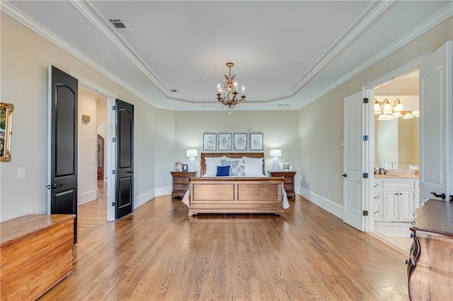 bedroom with a sink, a raised ceiling, light wood-style flooring, and a notable chandelier