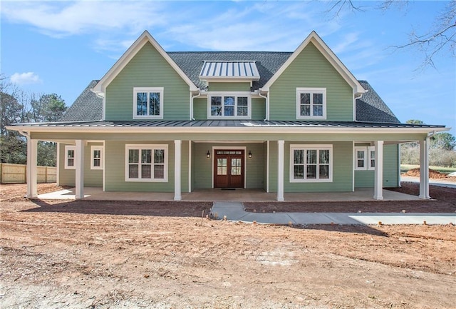 view of front of property featuring a shingled roof, french doors, fence, and a standing seam roof