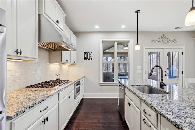 kitchen with white cabinetry, pendant lighting, stainless steel appliances, and a sink