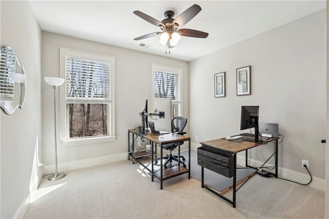 office area with light carpet, visible vents, a wealth of natural light, and a ceiling fan