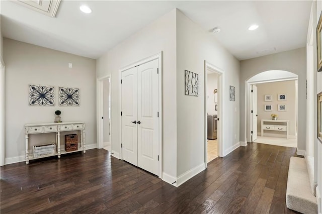 foyer with baseboards, arched walkways, dark wood-type flooring, and recessed lighting