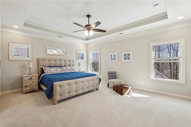 bedroom featuring baseboards, a tray ceiling, crown molding, and light colored carpet