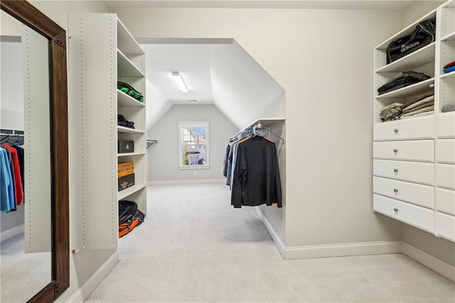 walk in closet with lofted ceiling and light carpet