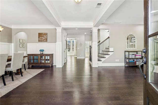 entryway featuring dark wood-style floors, crown molding, visible vents, ornate columns, and stairs