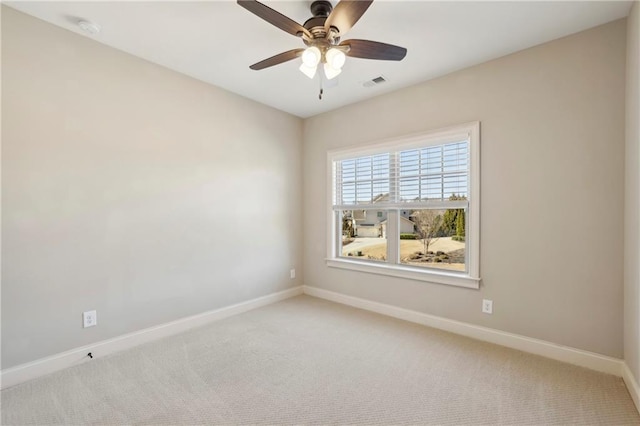 carpeted empty room featuring baseboards, visible vents, and a ceiling fan