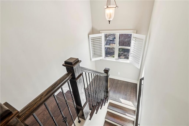 stairs with hardwood / wood-style floors and baseboards