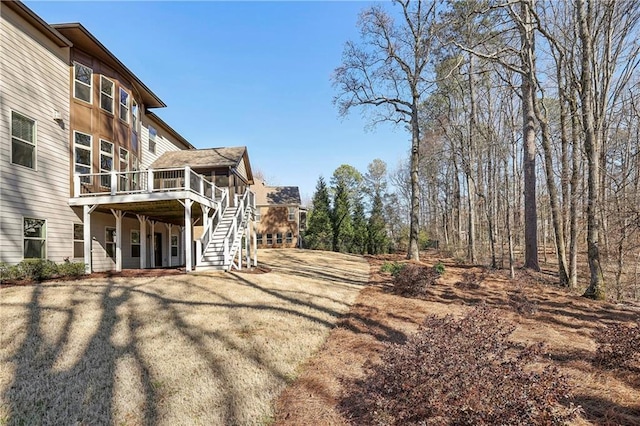 view of yard with a sunroom, a wooden deck, and stairs