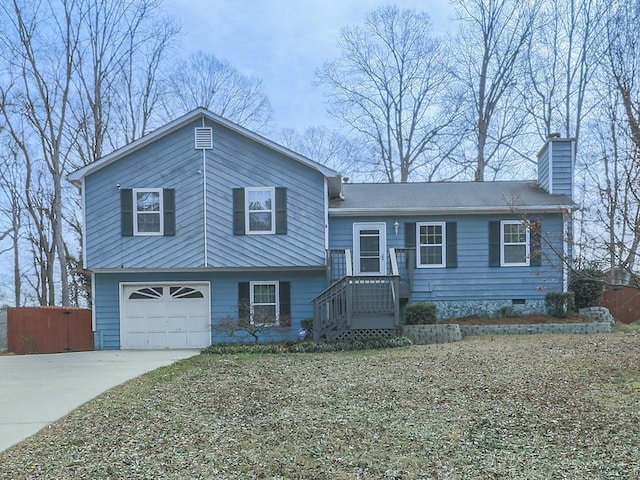 split level home with fence, a chimney, a garage, crawl space, and driveway