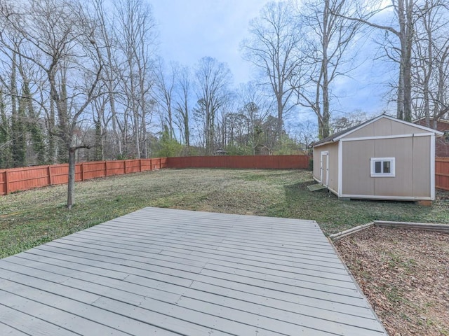 deck with an outbuilding, a yard, a storage unit, and a fenced backyard