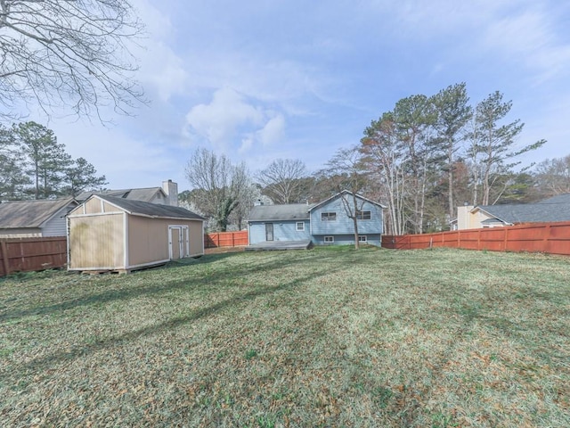 view of yard with an outbuilding, a fenced backyard, and a shed