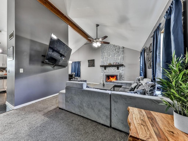 carpeted living room featuring baseboards, beam ceiling, a stone fireplace, and ceiling fan