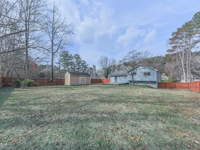 view of yard with a storage shed, a fenced backyard, and an outdoor structure