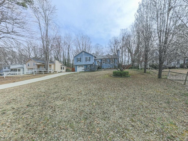 view of front of house with a garage, a gambrel roof, a front lawn, and driveway