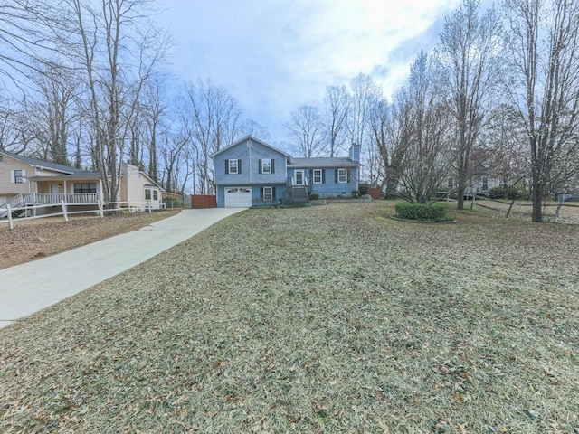 view of front of house featuring a chimney, concrete driveway, and an attached garage