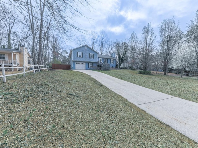 view of front of property with a front lawn, driveway, fence, a garage, and a chimney