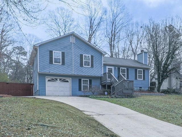 split level home with a front yard, fence, driveway, a chimney, and a garage