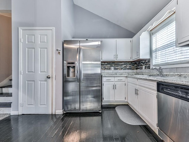 kitchen featuring dark wood-style floors, lofted ceiling, a sink, appliances with stainless steel finishes, and white cabinetry