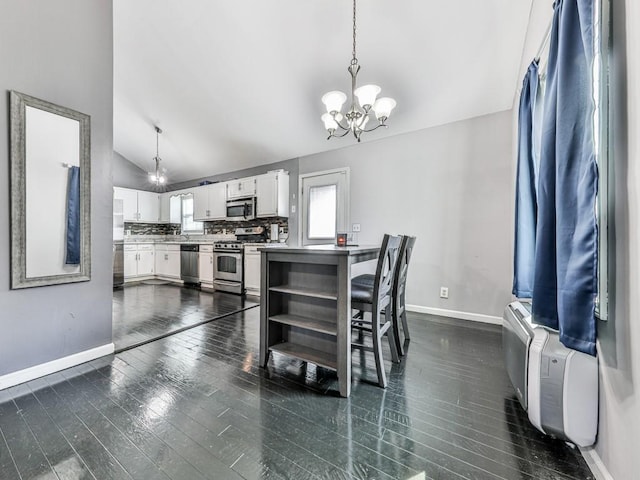 kitchen featuring a chandelier, lofted ceiling, appliances with stainless steel finishes, white cabinetry, and dark wood-style flooring