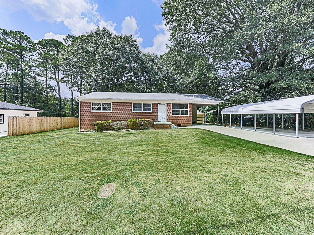 view of front of house featuring a carport and a front lawn