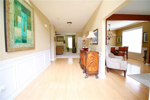 318 Ivy Manor Dr NW, Marietta, GA 30064 - hall featuring wood finished floors, a chandelier, wainscoting, and a decorative wall
