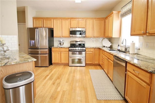 318 Ivy Manor Dr NW, Marietta, GA 30064 - kitchen with appliances with stainless steel finishes, a sink, decorative backsplash, light wood-style floors, and light stone counters