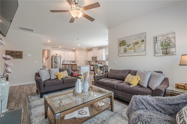 living area with wood finished floors, ceiling fan, recessed lighting, and baseboards